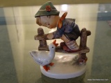 (LR) GOEBEL HUMMEL FIGURINE OF A BOY CLIMBING A FENCE WITH A GOOSE: 4.5