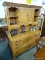 (ROW 3) MAPLE 2 PIECE HUTCH TOP CREDENZA. TOP HAS 2 CENTER DOORS AND 4 SIDE STORAGE AREAS WITH 2