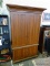 (ROW 5) CHERRY ENTERTAINMENT UNIT WITH 2 LOWER DOORS. UPPER DOORS OPEN TO REVEAL A TV STAND WITH