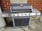 (OUT) BRINKMAN OUTDOOR GRILL WITH TEMPERATURE GAUGE ON THE TOP, 2 LOWER DOORS, AND 2 SIDE BURNERS.