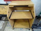 (ROW 1) ROLLING MAPLE SLANT FRONT COMPUTER DESK/WORKSTATION. HAS SLIDE OUT TRAY AND 1 LOWER SLIDE