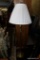 (R1) FLOOR LAMP; BRASS-TONE POST AND BASE WITH WHITE PLEATED SHADE AND BUTTERFLY TOP FINIAL DETAIL.
