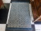 (R2) TEAL AND TAN AREA RUG; LOW PILE, SOLID BORDERS WITH ORNATE CLOVER PATTERN. MEASURES 2.5' X 4'.