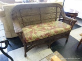 (R2) BROWN WICKER LOVESEAT; RICH DARK BROWN WICKER WITH A SINGLE SEAT CUSHION UPHOLSTERED IN A RED