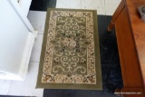 (R3) SMALL AREA RUG; OLIVE GREEN WITH CREAM/TAN/BLACK BORDER AND DESIGN. MEASURES 2' X 3'.