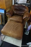 (R3) LEATHER CHAIR AND OTTOMAN; BROWN RIVETED ROLLED ARMS WITH SLIGHTLY ARCHING ATTACHED BACK.