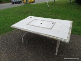 (OUT) TILE TOP PATIO TABLE, NEEDS A LITTLE TLC, OFF WHITE IN COLOR WITH GREY ACCENTS. MEASURES 40