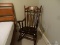 (BR2) VINTAGE WOODEN ROCKING CHAIR; DARK STAIN WITH GOLD PAINTED TRIM ON BACK RAIL, SLATS, AND