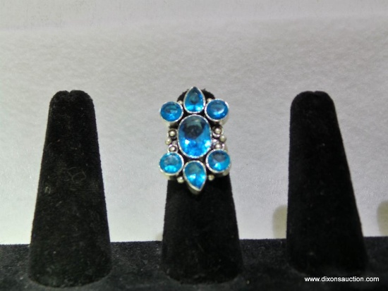 LARGE SILVER TONE LADIES RING SET WITH SYNTHETIC BLUE TOPAZ STONES. SIZE 7.5
