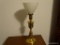 (MBR) TABLE LAMP; BRASS URN-STYLE LAMP WITH OPEN TOP WHITE GLASS SHADE ATTACHED. MEASURES 8
