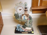 (K) DE ELMA SEASIDE CLOCK; MADE OF RESIN AND PAINTED TO LOOK LIKE A LIGHTHOUSE WITH A BOAT AND