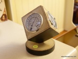 (K) NOYMER CUBE SHAPED LEATHER BOUND BAROMETER/ HYGROMETER/ THERMOMETER. SITS ATOP A ROUND BASE.