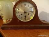 (LR) WOOD MANTEL CLOCK; DARK STAINED WITH DENTIL MOLDING ALONG BOTTOM WITH TRADITIONAL ARCH SHAPE