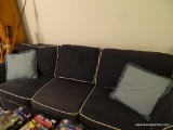(LR) NAVY BLUE SOFA WITH WHITE PIPING TRIM; THIS COUCH IS COVERED WITH A DENIM-COLORED UPHOLSTERY,