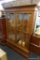 (R3) LARGE OAK GUN CABINET WITH 2 GLASS-FRONT DOORS; 2 GLASS FRONT DOORS WITH CROSS-GRID TRIM OVER 2