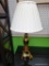 (R4) TABLE LAMP; BRASS URN STYLE ON A SQUARE BLOCK BASE WITH 4 FEET BELOW. IVORY COLORED PLEATED