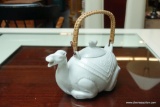 (R2) WHITE PORCELAIN CAMEL TEAPOT WITH WOVEN HANDLE; MEASURES 8 IN LONG AND 8 IN TALL (WITH HANDLE).