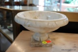 (R3) WHITE ALABASTER PEDESTAL BOWL; CARVED EDGE, SITS ATOP A SQUARE BASE. MEASURES 8 IN DIAMETER AND