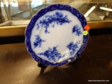 (R5) STANLEY POTTERY DINNER PLATE; TOURAINE, FLOW BLUE PATTERN, ON BLACK PLASTIC FOLDING PLATE