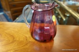 (R5) PINK OPALESCENT GLASS SINGLE HANDLED PITCHER WITH CLEAR HANDLE AND RUFFLED EDGE; MEASURES 5 IN