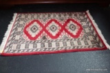 (R5) PERSIAN STYLE RUG; MEASURES 2 FT X 3 FT, HAS WHITE FRINGE ON EACH END, RED WITH SHADES OF TAN