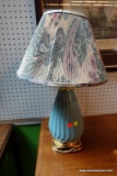 (R5) TABLE LAMP POWDER BLUE BASE WITH GOLD TONE BOTTOM. PLEATED FLORAL SHADE. 23 IN H X 13 IN D