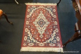(R1) AMERICAN ALTERNATIVE PERSIAN-STYLE AREA RUG; RED WITH TAN AND BLUE FLORAL BORDER AND CENTRAL
