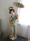 (BED) PORCELAIN GEISHA GIRL STATUE; HOLDING PARASOL, IN MUTED SHADES OF TAN, BLUE, RED, AND YELLOW,