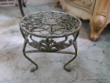 (BED) SMALL WROUGHT IRON FOOTSTOOL; 3 SCROLLING LEGS, PAINTED A LIGHT GREEN , HAS FLORAL DETAIL ON