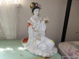 (BED) PORCELAIN GEISHA GIRL STATUE; VERY FORMALLY DRESSED WOMAN IN A KNEELING POSE. REDS AND PASTELS