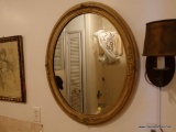 (BA) OVAL MIRROR; ORNATE GOLD ACCENTED OVAL SHAPED MIRROR. THIS MIRROR HAS A BEAUTIFUL SCROLLING
