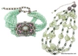 2 LARGE LIGHT JADE COLORED NECKLACES. 1 IS A 3 STRAND NECKLACE WITH A HOOK CLASP AND THE OTHER IS A