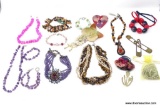 BAG LOT OF VARIOUS COSTUME JEWELRY. INCLUDES A HOT PINK PUKKA SHELL NECKLACE, A LARGE HEART BROOCH,