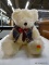 PLUSH WHITE TEDDY BEAR WITH PLAID VEST AND BOW TIE; MEASURES 11 INCHES TALL FROM SEATED POSITION.