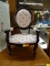 DOLL SIZED VICTORIAN ARMCHAIR; CARVED WOODEN FRAME WITH DARK STAIN, UPHOLSTERED ROUND PORTRAIT BACK