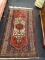 VINTAGE MIDDLE EASTERN RUG; IN DEEP RED, BLUE AND CREAM. MEASURES 34 IN X 64 IN