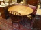 WOODEN ROUND DINETTE SET; INCLUDES A ROUND CHERRY SPADE FOOTED DINING TABLE AND 4 CHERRY BOW BACK