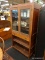 CHERRY STORAGE CABINET; HAS 2 GLASS DOORS WITH 2 WOODEN SHELVES, OVER 1 DRAWER OVER 1 SHELF STORAGE