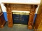MAHOGANY FIREPLACE MANTLE; HAS CUBE PATTERNED BACK AND REEDED SIDES. MEASURES 38 IN X 15 IN X 50 IN