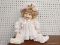 LARGE BABY DOLL; IN PINK OUTFIT WITH PINK AND FLORAL BONNET. HAS PORCELAIN FACE, HANDS AND BLONDE