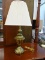 BRASS BASE TABLE LAMP; TURNED AND FLUTED URN STYLE BASE WITH PLEATED CREAM COLORED LINEN SHADE.