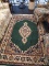DARK GREEN AREA RUG; WITH CREAM, TAN, AND MAROON CENTRAL MEDALLION AND FLORAL BORDER AND CREAM