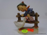GOEBEL HUMMEL FIGURINE; DEPICTS A LITTLE BOY CLIMBING A FENCE WITH A GOOSE. MEASURES 5 IN TALL. MADE