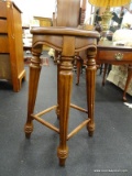 ROUND WOODEN BARSTOOL; REEDED COLUMN LEGGED WITH FOOTRESTS. MEASURES 13 IN TALL X 24 IN DIAMETER.