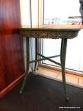 ROUND GREEN WOOD AND WICKER TABLE; ROUND TOP WITH WICKER APRON, PAINTED IN A CHIPPY GREEN PAINTED