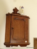 (BED1) WALL HANGING CORNER CABINET WITH 1 DOOR AND UPPER SHELF AREA. APPROXIMATELY 12 IN X 8 IN X 25