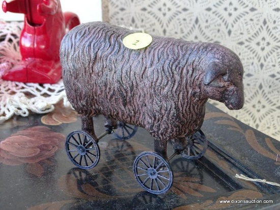 VINTAGE SHEEP PULL-TOY; SITS ON A PAIR OF ROLLING WHEELED AXLES, METALLIC BLACK AND BRONZED COLOR.