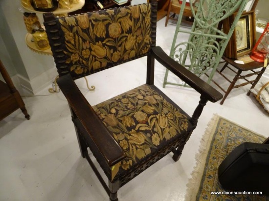 ANTIQUE DARK WOOD FRAME UPHOLSTERED ARMCHAIR; SQUARED BACK WITH BLACK FLORAL UPHOLSTERY, RIVETED