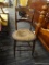VINTAGE CANE SEAT CHAIR; WOODEN CHAIR WITH A SCALLOPED TOP AND CENTER RAIL SUPPORTED BY POSTS THAT