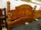 WOOD QUEEN SIZED BED; THIS BEAUTIFUL BED HAS TURNED CANNON BALL POSTS WITH ARCHED HEAD BOARD. THE